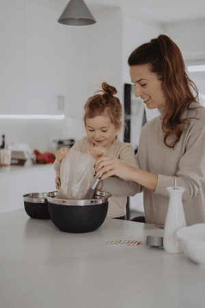 Mother and child baking lemon muffins.