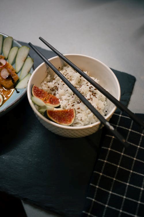 chopsticks placed on a cilantro lime salmon bowl 