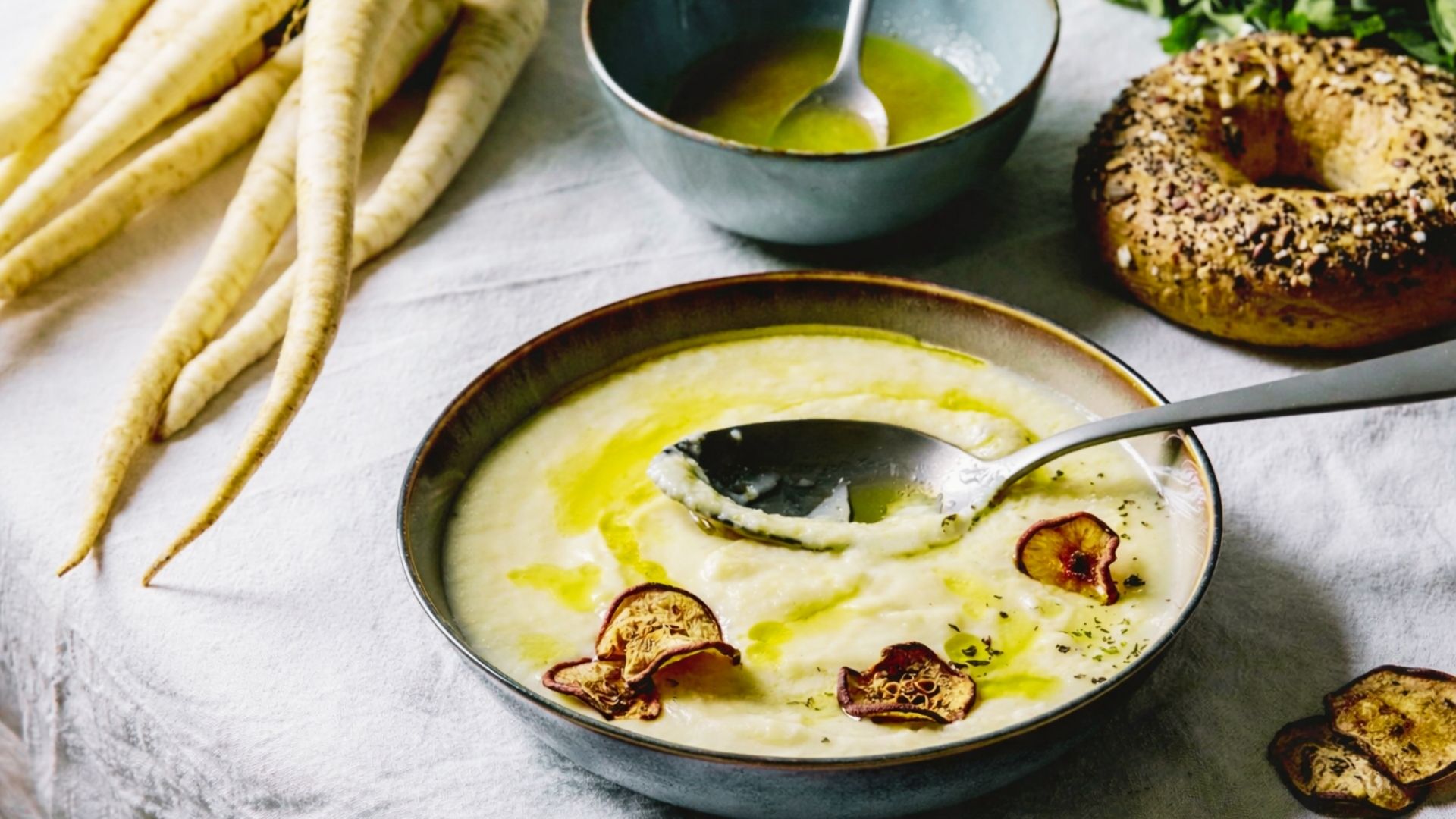 Creamy Parsnip and Celery Root Bisque with olive oil drizzle and crispy parsnip chips