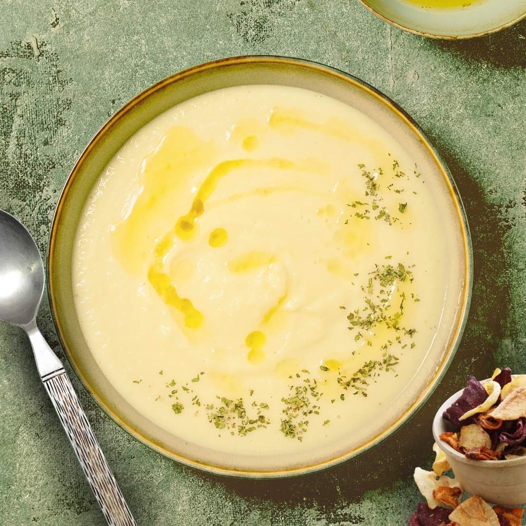 Close-up of creamy parsnip and celery root bisque with olive oil drizzle.